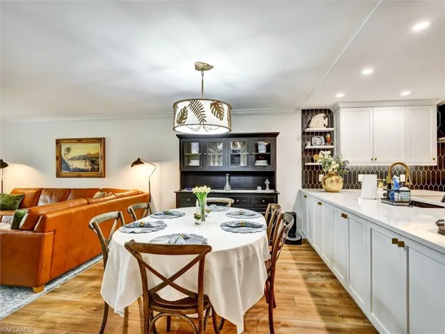 Dining area featuring light wood-type flooring, ornamental molding, and recessed lighting