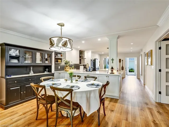 Dining room featuring light wood-style flooring, recessed lighting, and ornamental molding