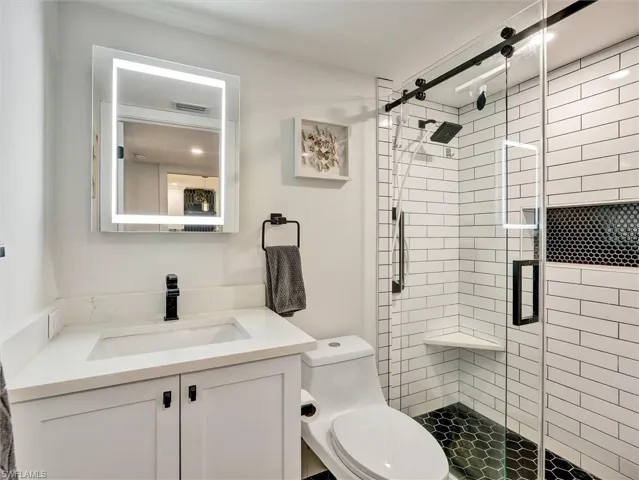 Full bathroom featuring vanity and a shower stall