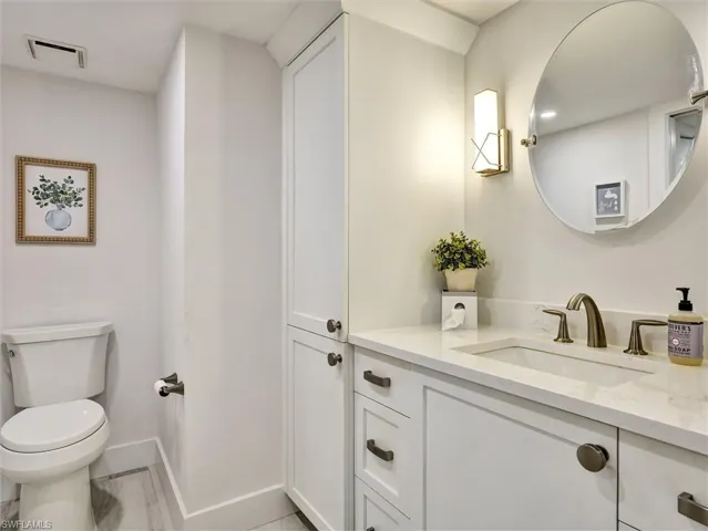 Half bathroom featuring vanity and toilet