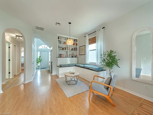 Living area with light wood-type flooring and built in features