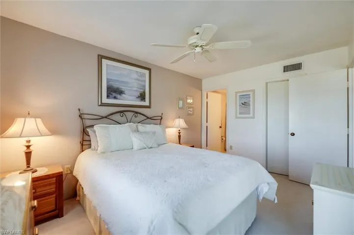 Carpeted bedroom featuring a closet and ceiling fan