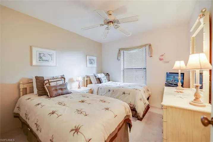 Carpeted bedroom featuring ceiling fan