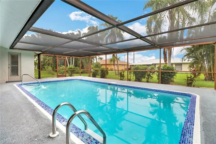 View of swimming pool featuring a patio and glass enclosure