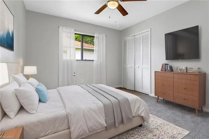 Carpeted bedroom featuring a closet and ceiling fan