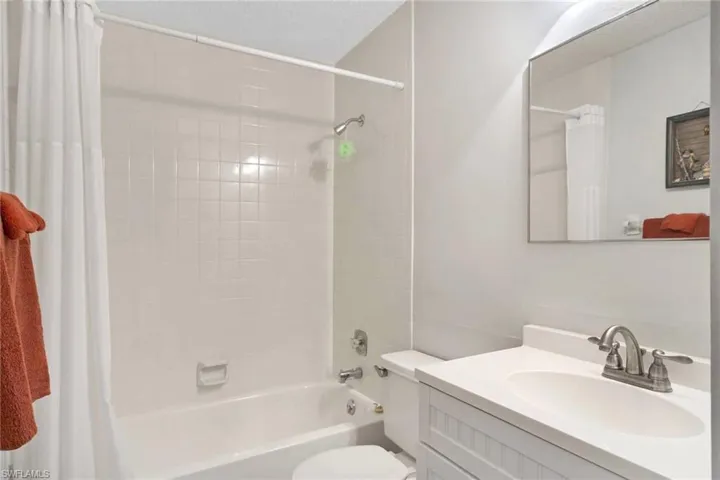 Full bathroom featuring toilet, vanity, and shower / tub combo with curtain