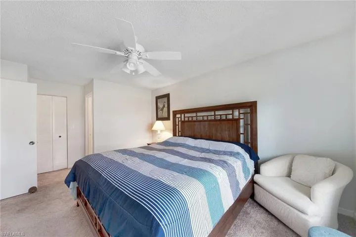 Bedroom featuring ceiling fan, light colored carpet, a closet, and a textured ceiling