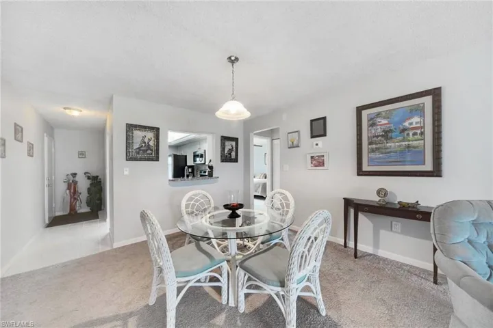 Dining area with light colored carpet and a textured ceiling
