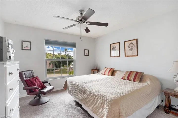 Bedroom featuring ceiling fan, carpet, and a textured ceiling