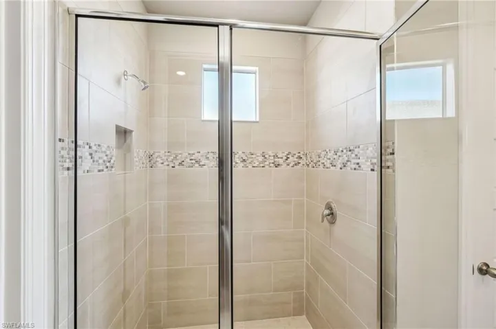 Bathroom featuring a healthy amount of sunlight and walk in shower