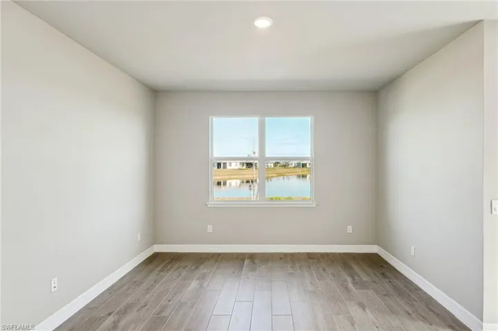 Spare room featuring light wood-type flooring and a water view