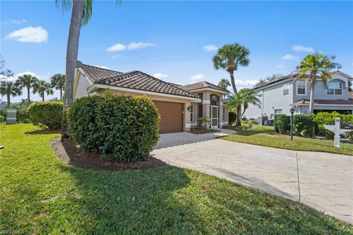 Mediterranean / spanish-style home with a front yard, a tile roof, stucco siding, decorative driveway, and an attached garage