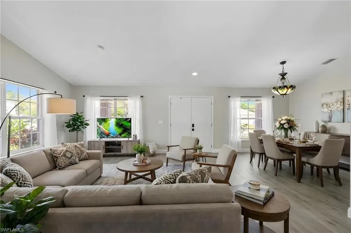 Living room featuring vaulted ceiling, light wood-type flooring, and recessed lighting