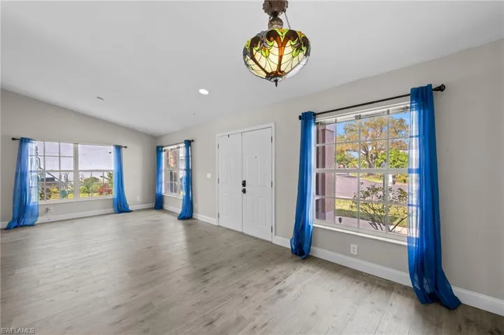 Entrance foyer featuring light wood finished floors, vaulted ceiling, and recessed lighting