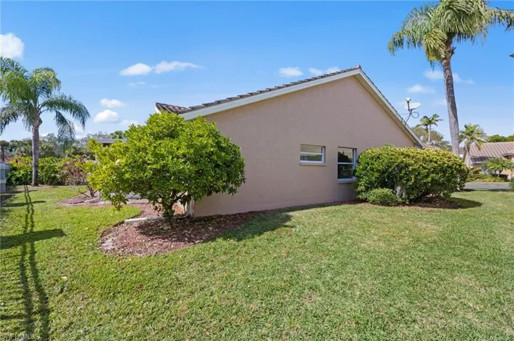 View of property exterior with stucco siding and a lawn