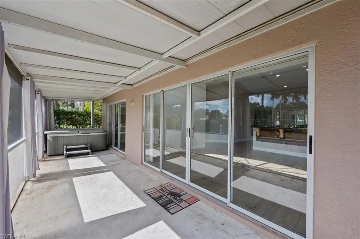 Unfurnished sunroom with a hot tub