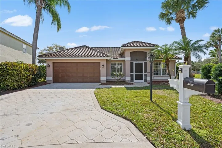 Mediterranean / spanish house with stucco siding, decorative driveway, a tile roof, a front yard, and a garage