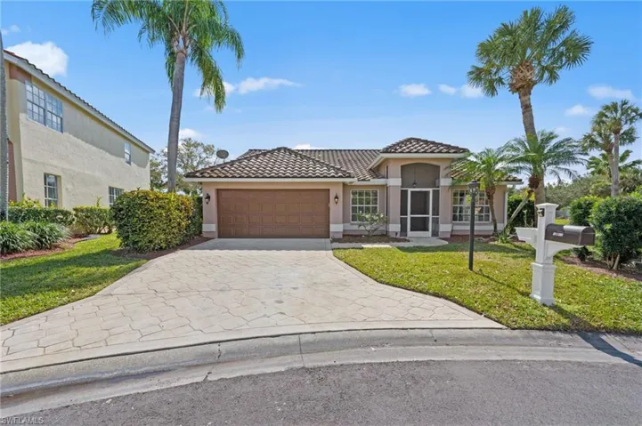 Mediterranean / spanish home featuring a front yard, stucco siding, driveway, a tile roof, and a garage