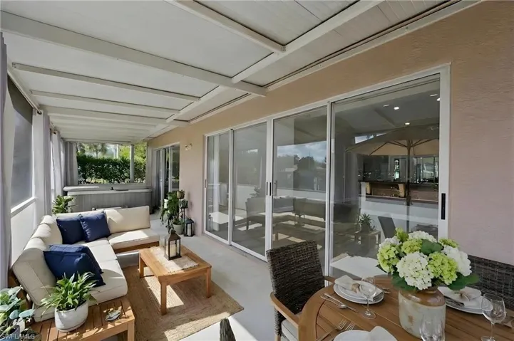 Sunroom with outdoor furniture, concrete flooring, and beam ceiling