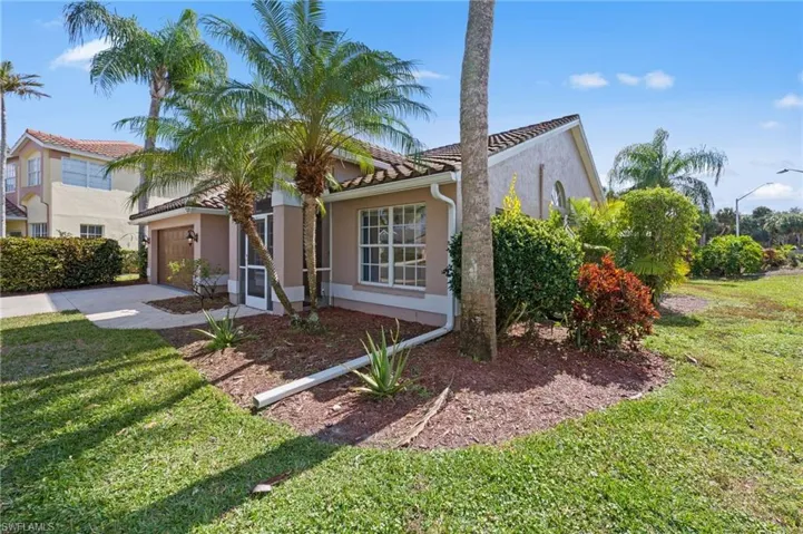 Mediterranean / spanish-style home featuring a garage, a tiled roof, driveway, a front lawn, and stucco siding