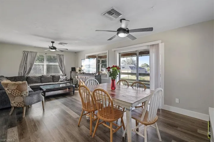 Dining space with dark wood-style floors and a ceiling fan