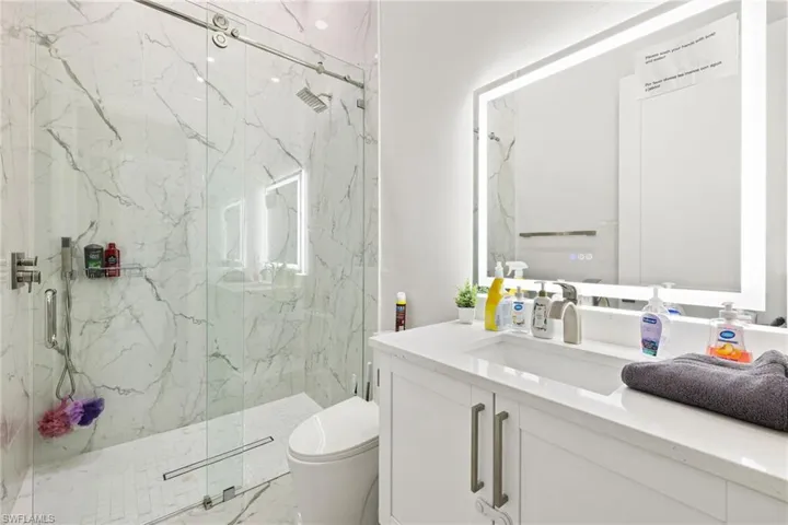 Bathroom with a marble finish shower and vanity