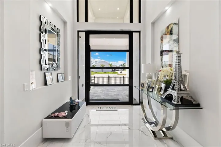 Foyer with light marble finish flooring and a high ceiling