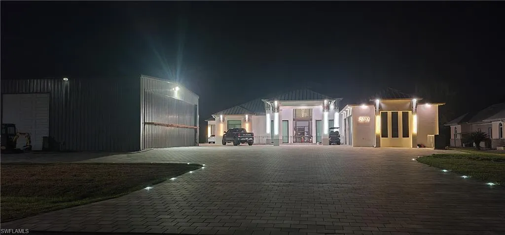 View of front facade featuring decorative driveway and stucco siding