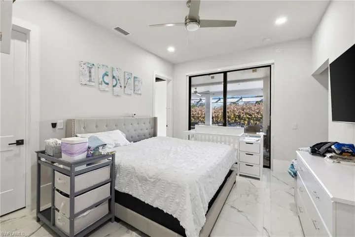 Bedroom featuring recessed lighting, ceiling fan, and light marble finish flooring