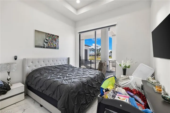 Bedroom featuring access to exterior, marble finish floors, and recessed lighting