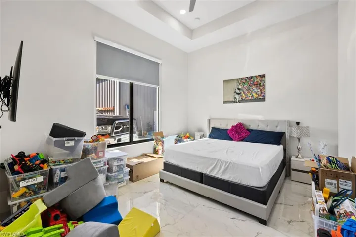 Bedroom with light marble finish flooring, recessed lighting, and ceiling fan