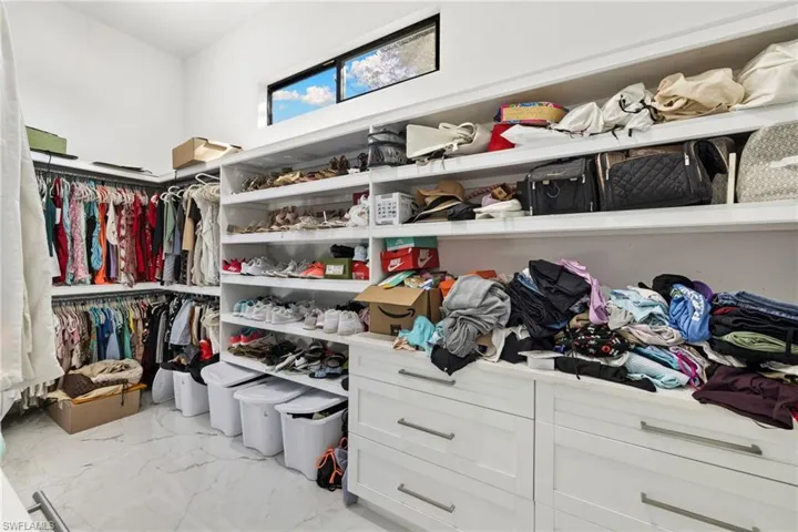 Walk in closet with light marble finish floors