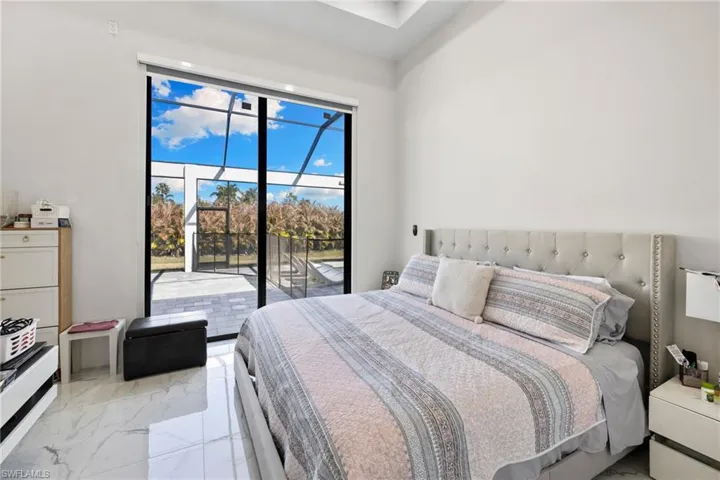Bedroom featuring light marble finish floors and access to exterior