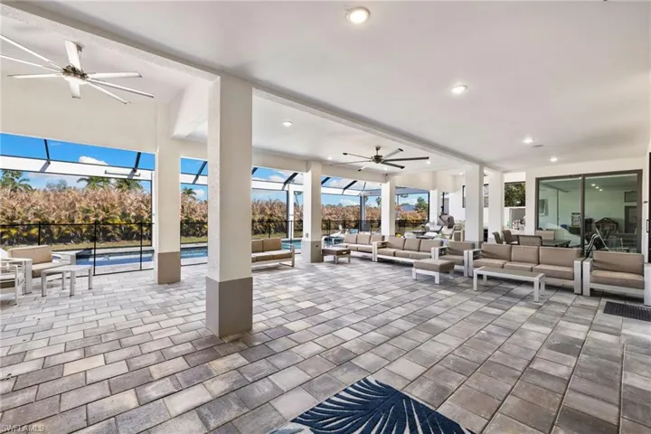 View of patio featuring a ceiling fan, outdoor lounge area, an outdoor pool, and a lanai