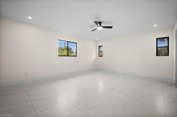 Empty room with light marble finish floors, recessed lighting, and ceiling fan