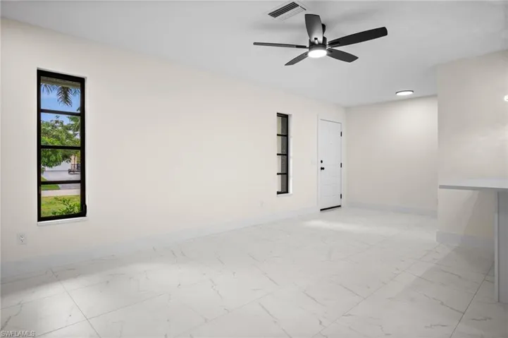 Spare room with light marble finish floors and a ceiling fan