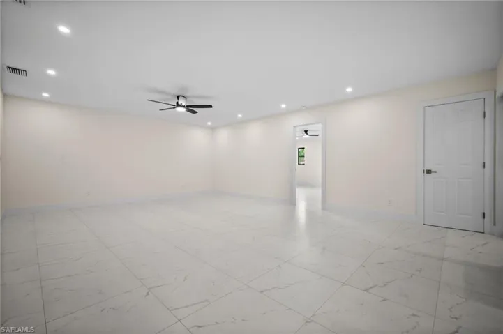 Empty room featuring light marble finish flooring, a ceiling fan, and recessed lighting