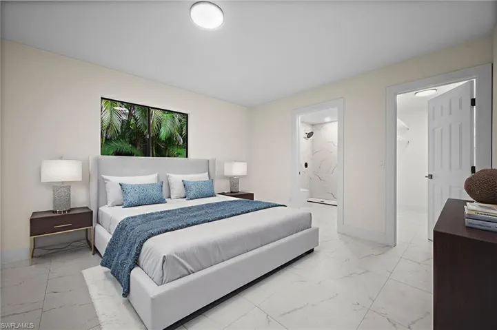 Bedroom with light marble finish floors and a walk in closet