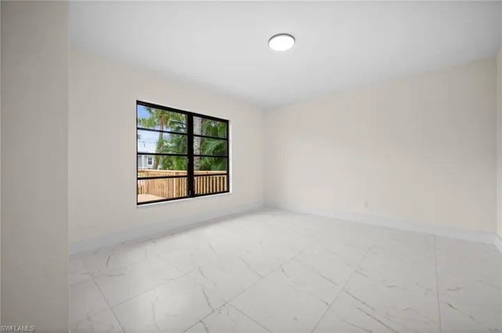 Unfurnished room with light marble finish floors and baseboards
