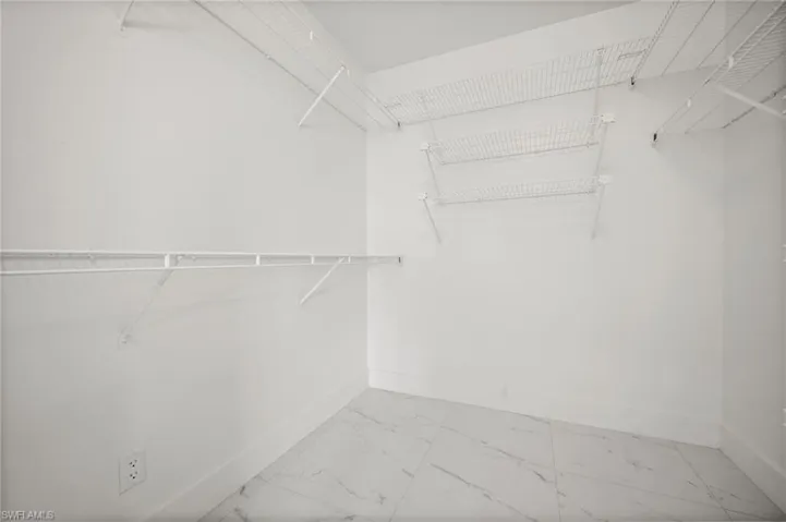 Spacious closet with light marble finish floors