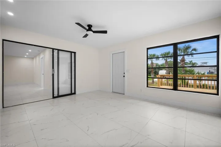 Unfurnished room featuring light marble finish flooring, ceiling fan, and recessed lighting