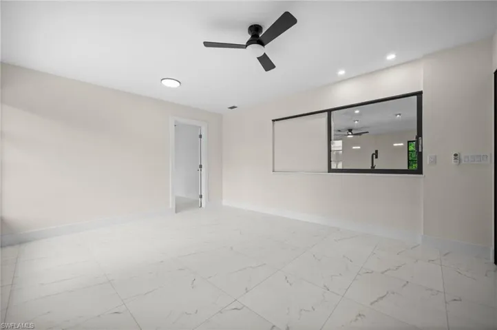Spare room featuring light marble finish flooring, ceiling fan, and recessed lighting
