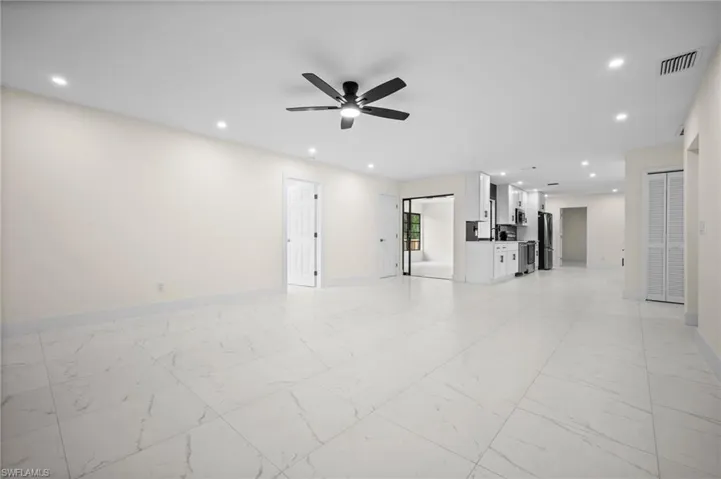 Unfurnished living room with light marble finish floors, recessed lighting, and ceiling fan