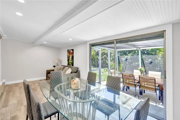 Dining room with light wood-type flooring, recessed lighting, and beam ceiling