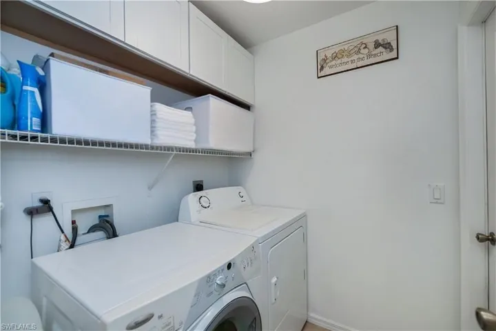 Laundry area with cabinet space, independent washer and dryer, and baseboards