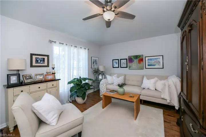Living area featuring dark wood-type flooring and a ceiling fan