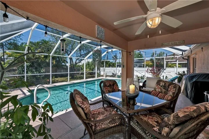 Outdoor pool with a fenced backyard, a lanai, a patio, and a ceiling fan