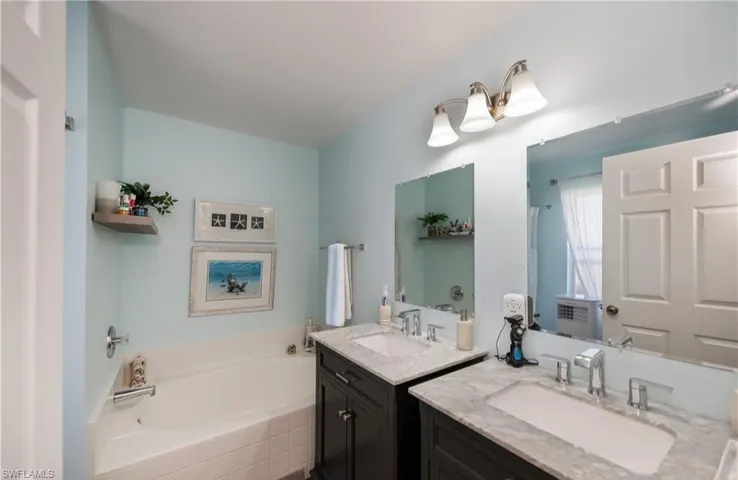Bathroom featuring a garden tub and two vanities
