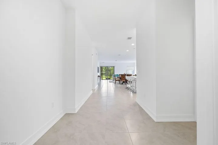 Corridor featuring light tile floors
