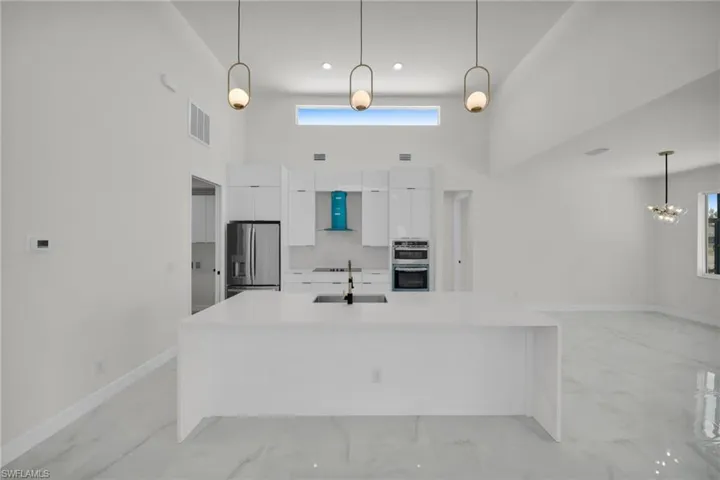 Kitchen with appliances with stainless steel finishes, marble finish floor, a sink, visible vents, and modern cabinets